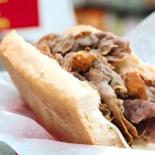 Close-up of a Lee's Deli sub-sandwich, generously filled with thinly sliced roast beef.